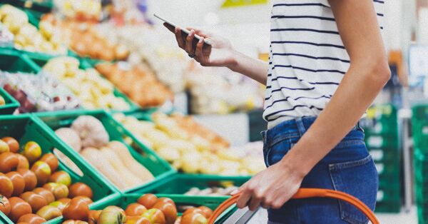 A customer using a mobile device in a grocery