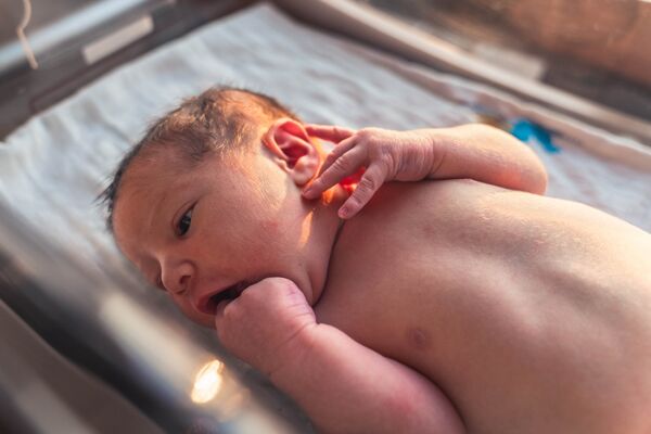 Beautiful Newborn Baby Boy, Laying In Crib at Hospital