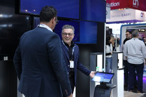 Senior Sales Manager Jochen Goppold introduces the SOLUM Smart Robot to a booth visitor.